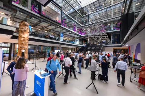 The Entrance of the House of Communication which is filled with people during a conference.