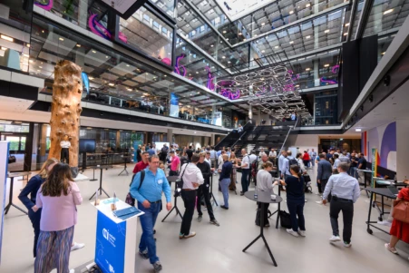 Der Eingang des House of Communication, der während einer Konferenz mit Menschen gefüllt ist.