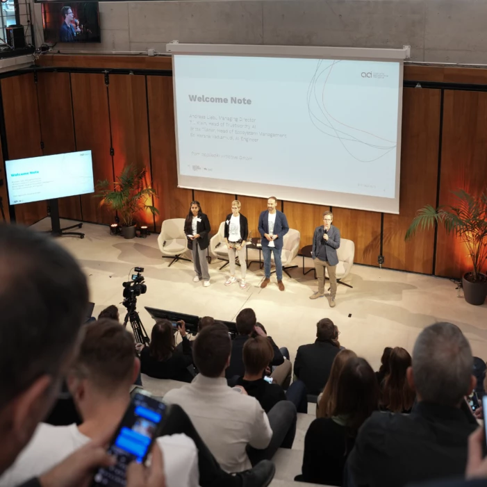 Blick auf die Bühne auf der ein Panel Talk zwischen KI-Experten stattfindet