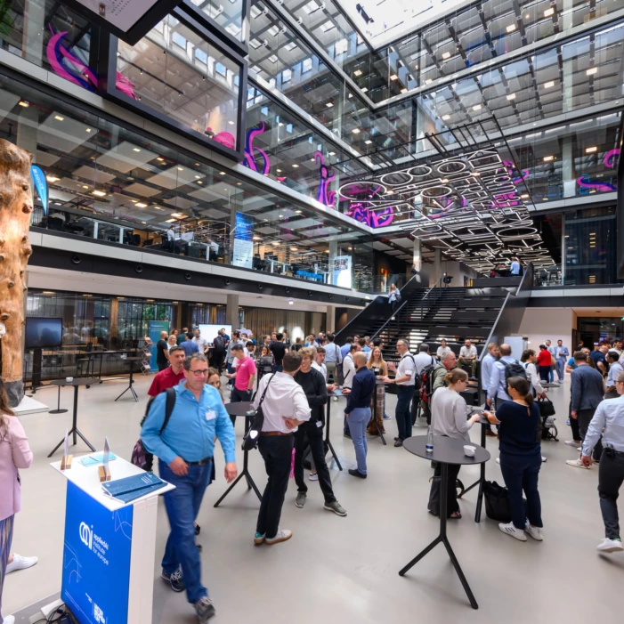 The Entrance of the House of Communication which is filled with people during a conference.