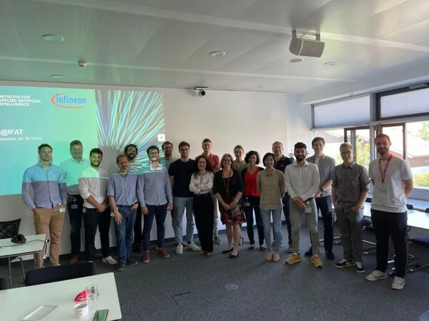 Circa 20 Personen stehen für ein Gruppenbild in einem Workshop-Raum